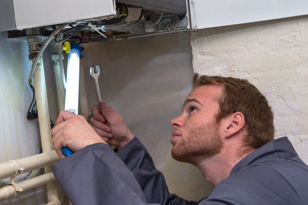 Technician controlling the heating system — Air Conditioner Repairs in Bateau Bay NSW