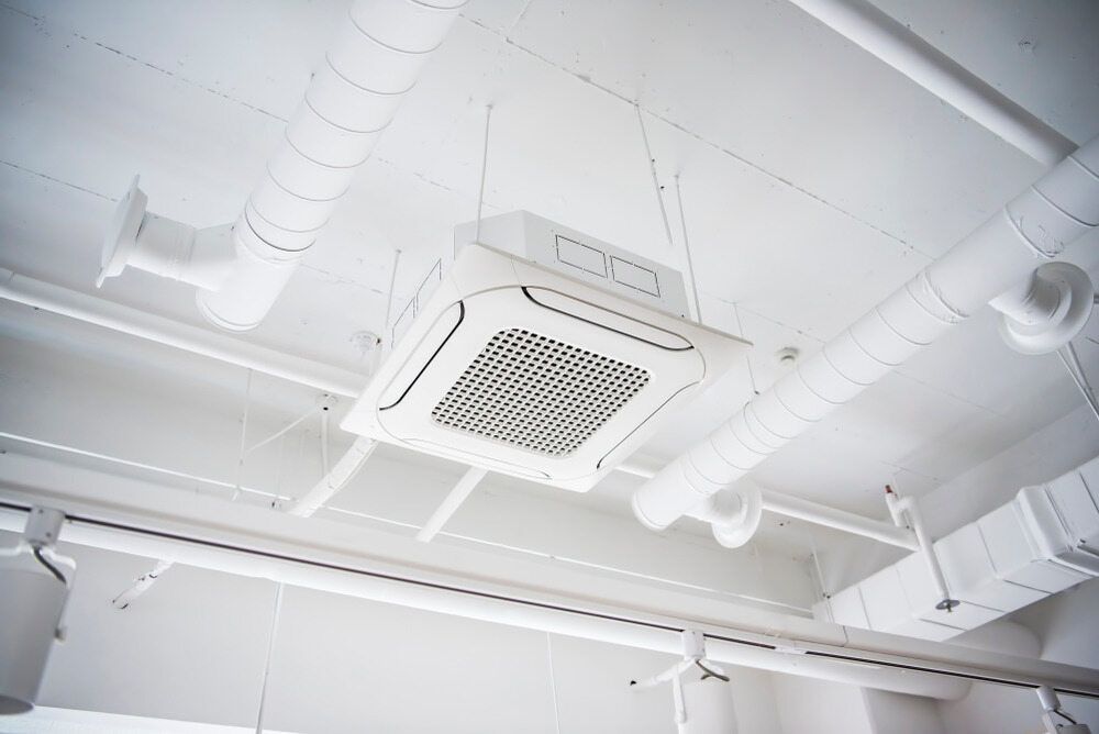 A White Air Conditioner Is Hanging From The Ceiling Of A Building — Bear Air Conditioning In Hamlyn Terrace, NSW