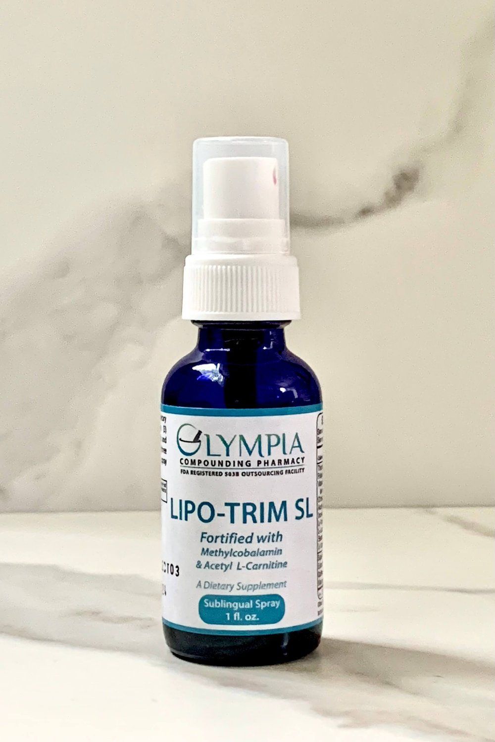 A bottle of lipo trim sitting on top of a marble counter.