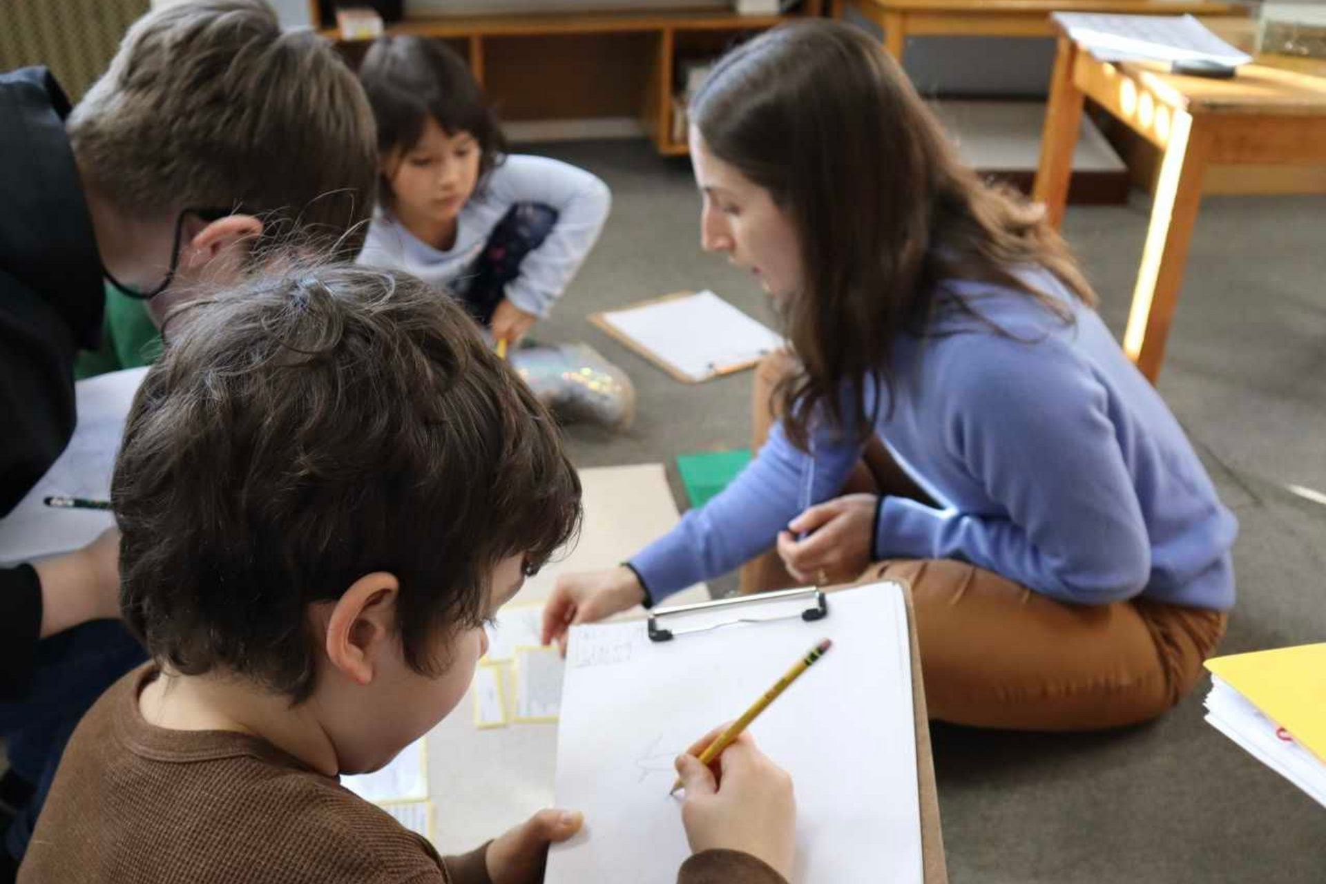 Students in a Montessori elementary classroom engaged in a collaborative small-group lesson with a teacher