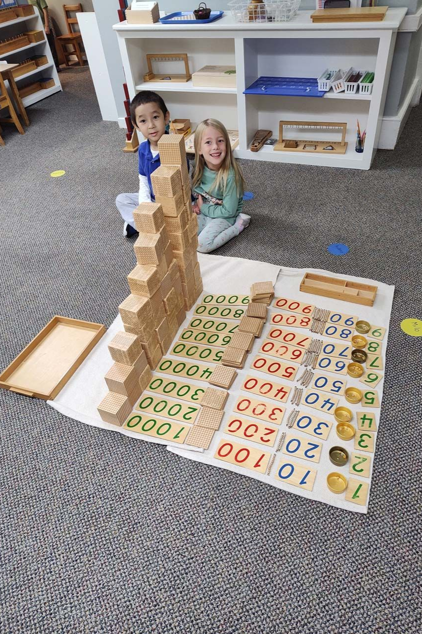Montessori primary children building the hierarchy of numbers with the Golden Beads