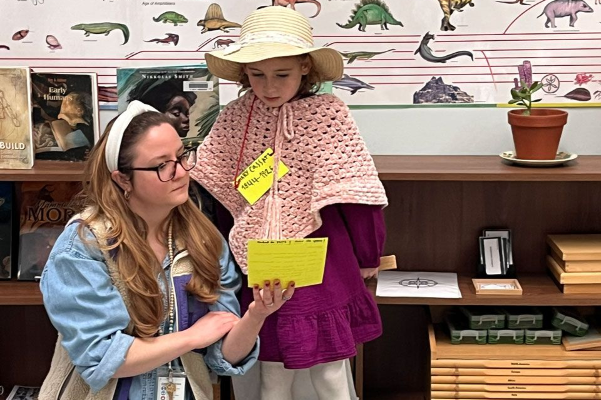 Montessori teacher assisting child dressed as a historical figure
