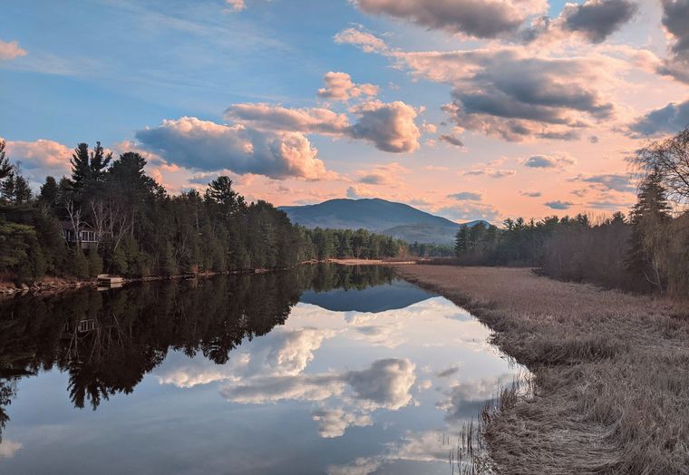 Two people holding hands, offering comfort. One in yellow skirt and blue cardigan, the other in blue shirt.