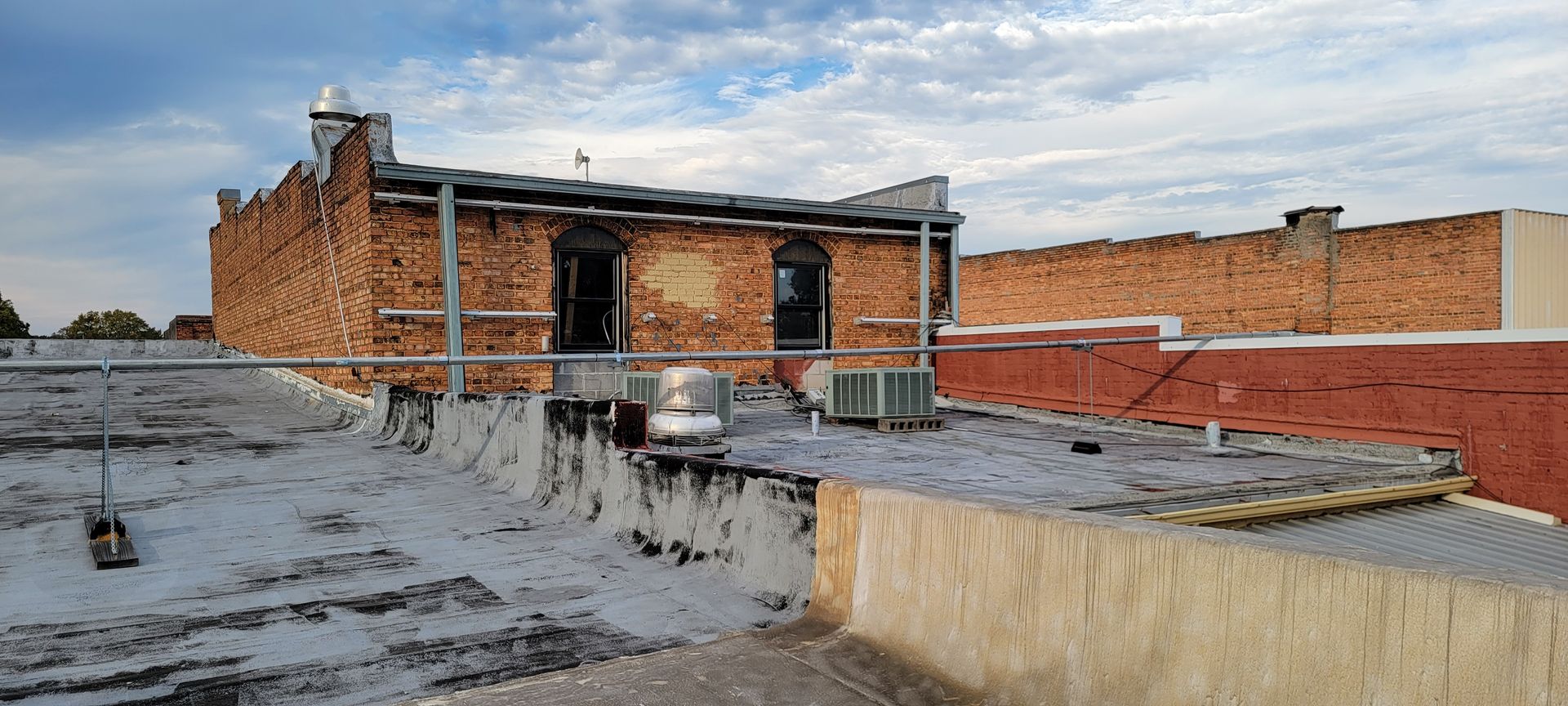 Wooden ceiling under construction with plumbing pipes visible.