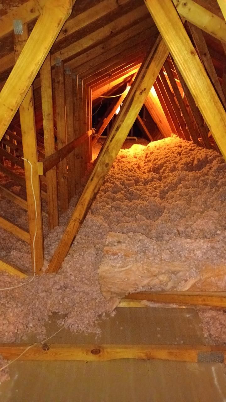 Wooden ceiling framework with plumbing pipes installed; construction site.