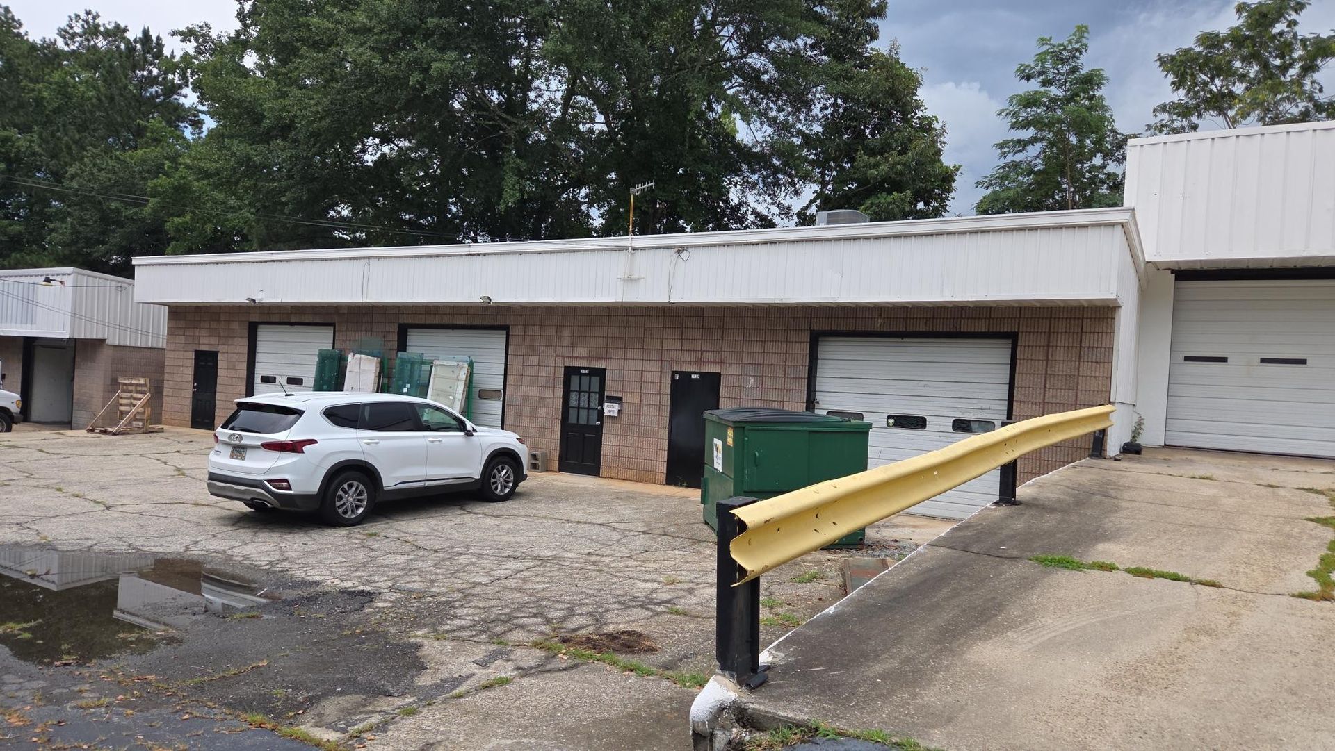 Two construction workers stand outside new townhouses with brick and green accents.