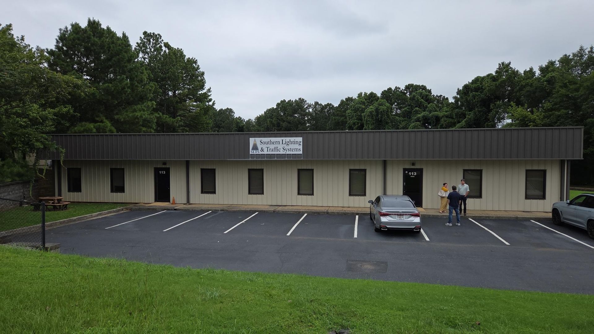 Brick building with a porch, black shutters, and accessible parking signs.