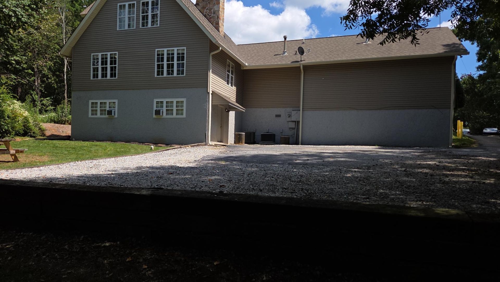 Inspector in hard hat and vest, inspecting a house window, holding a clipboard.