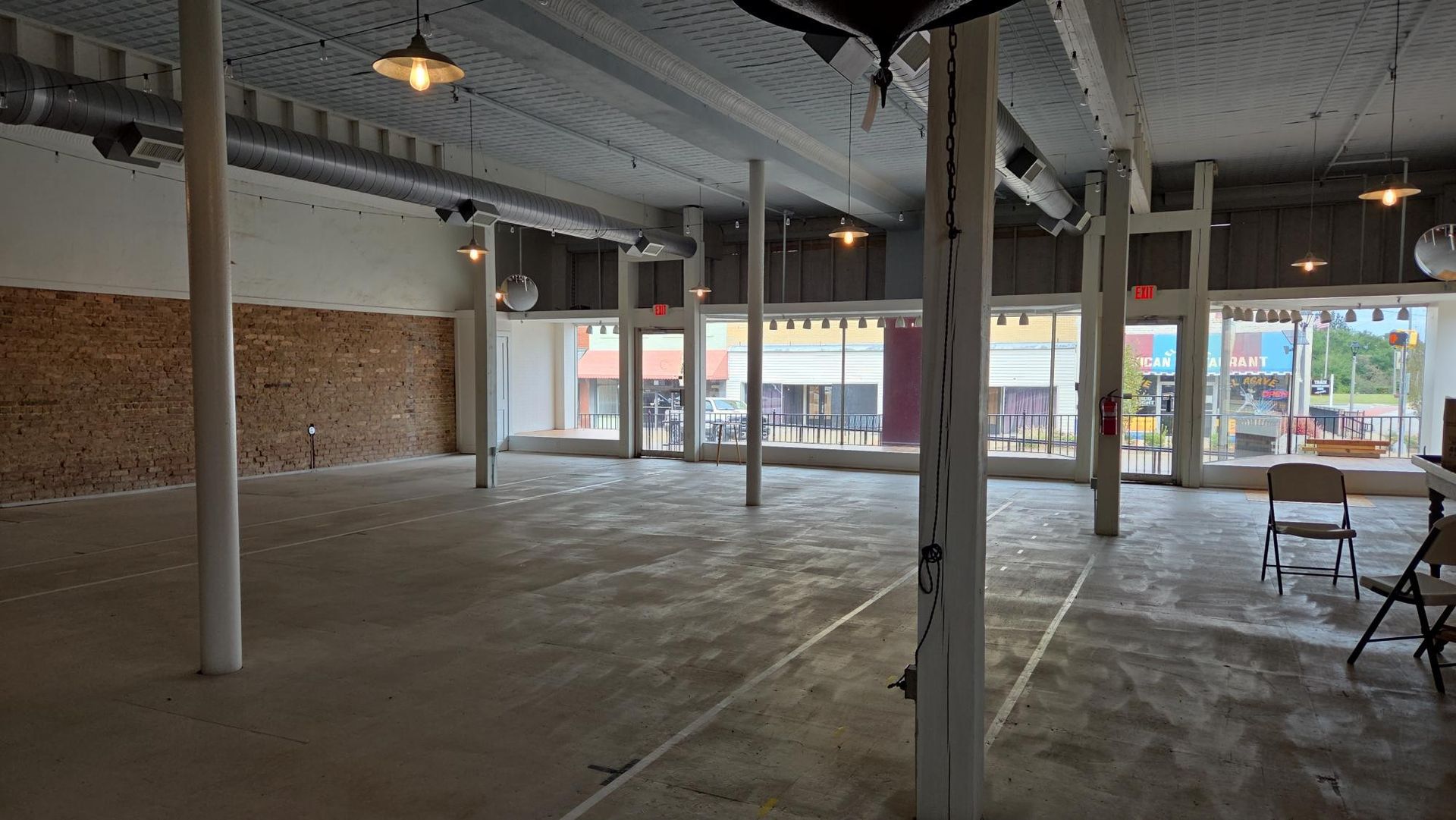 Person in blue overalls welds metal in an industrial setting.