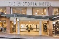 Entrance of The Victoria Hotel, with glass doors and a canopy. White signage.