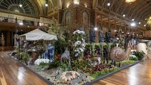 Large ornate display with sculpture and plants in a building. Brown building interior.