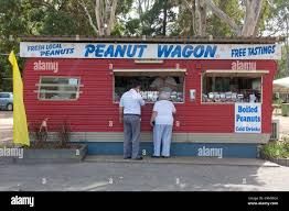 Red peanut wagon stand with free tastings, two customers at the counter