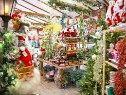 Christmas shop filled with decorations, featuring Santa figures and green trees.