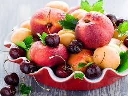 Bowl of fresh fruit: peaches, cherries, apricots, and nectarines, red and yellow colors.