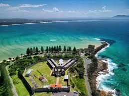 An aerial view of a castle on a small island next to the ocean.