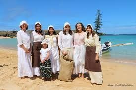 A group of women are posing for a picture on a beach.