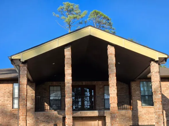 A large brick house with a porch and columns