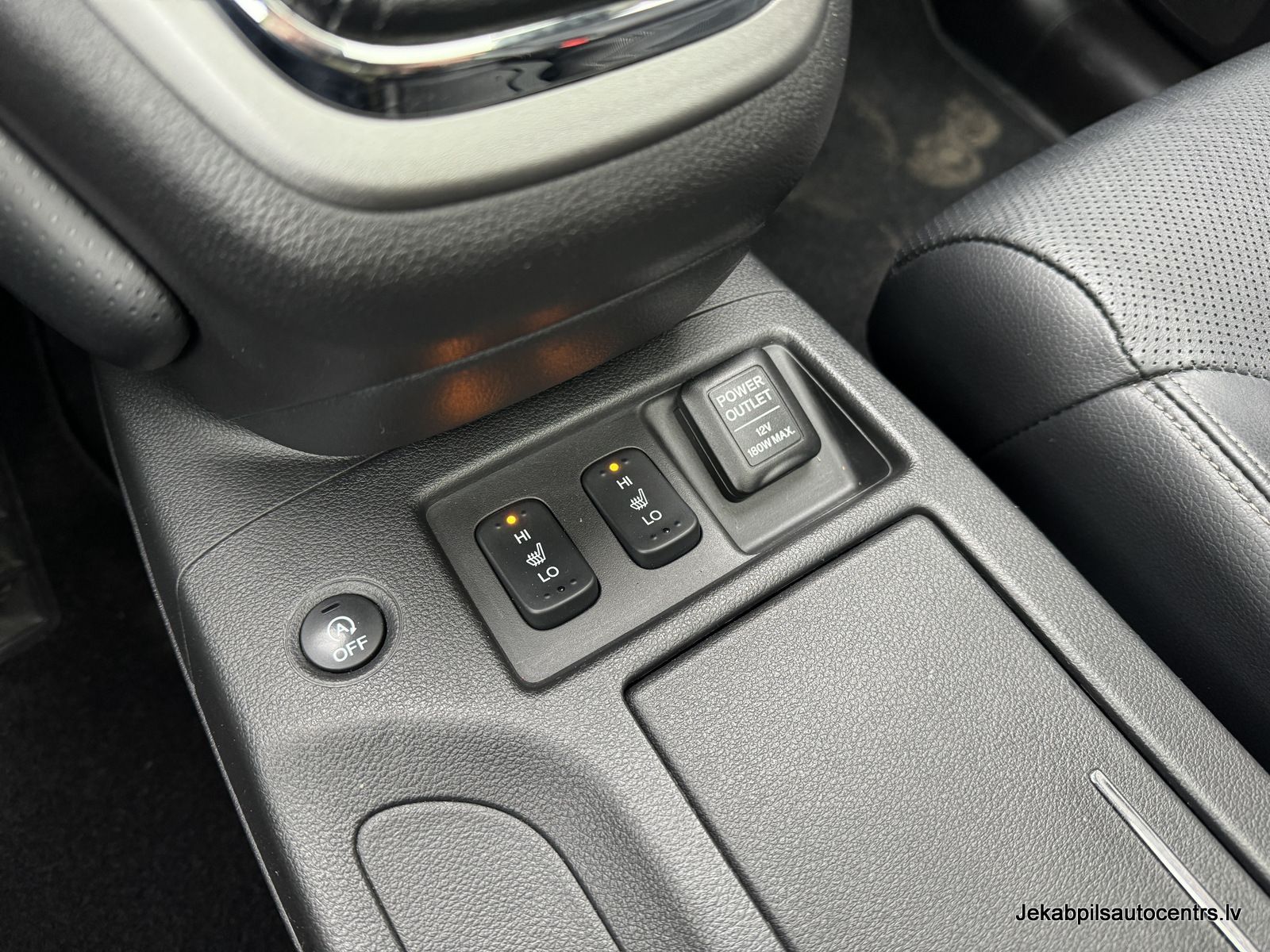 Tuvplāns automašīnas viduskonsolei ar dažām pogām uz tās.