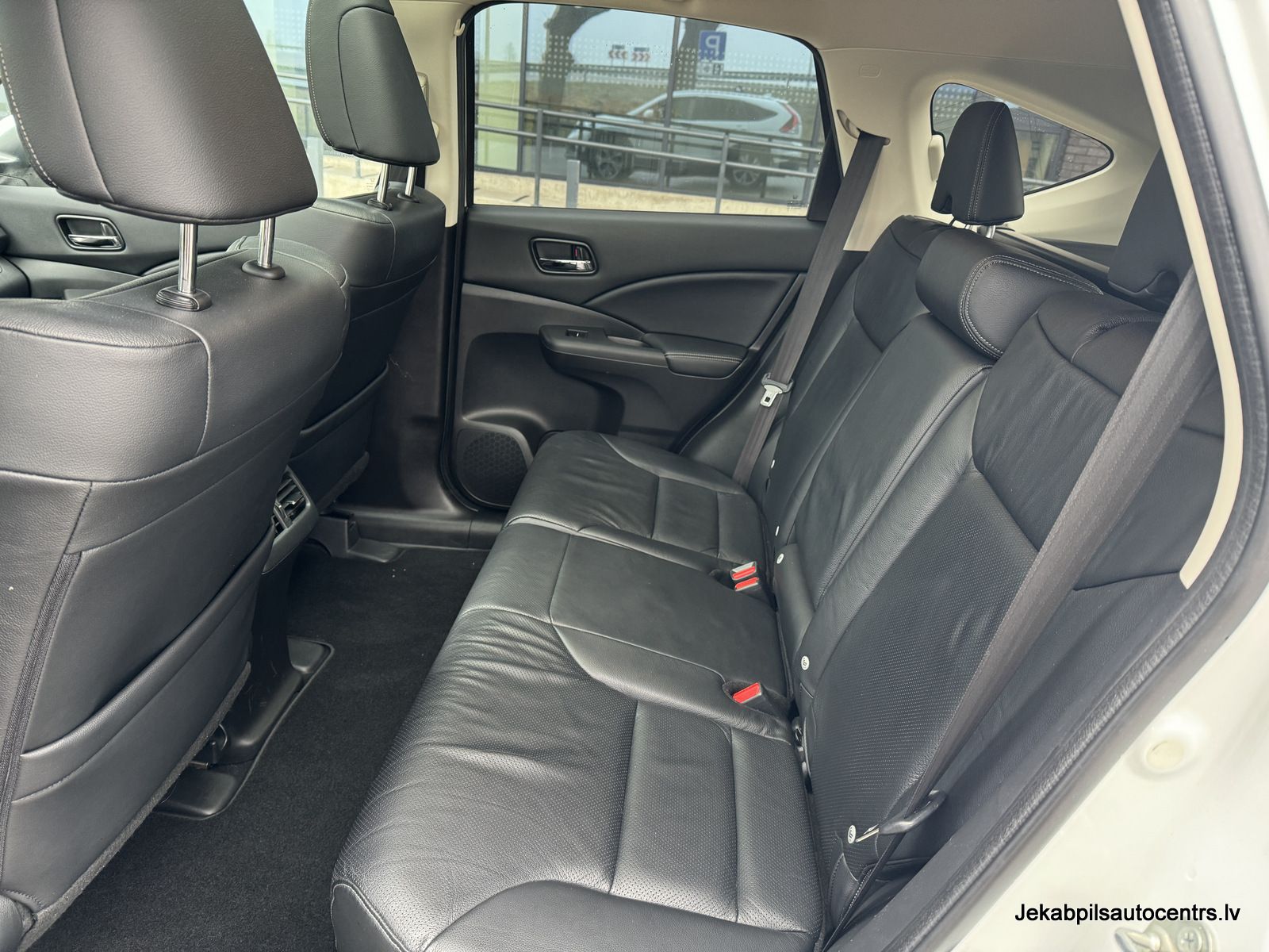 Automašīnas aizmugurējais sēdeklis ar melniem ādas sēdekļiem