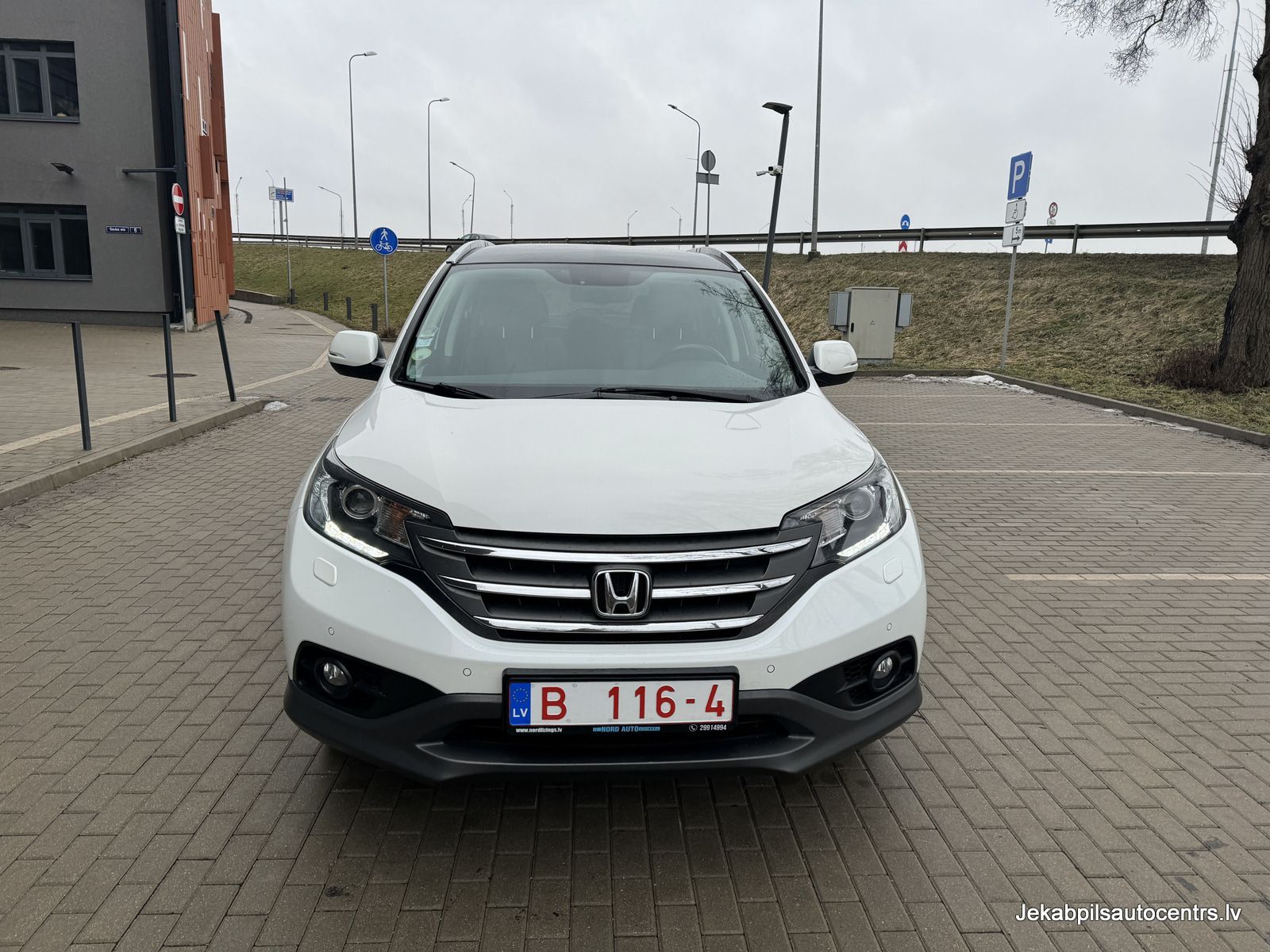 Autostāvvietā ir novietota balta honda cr v.