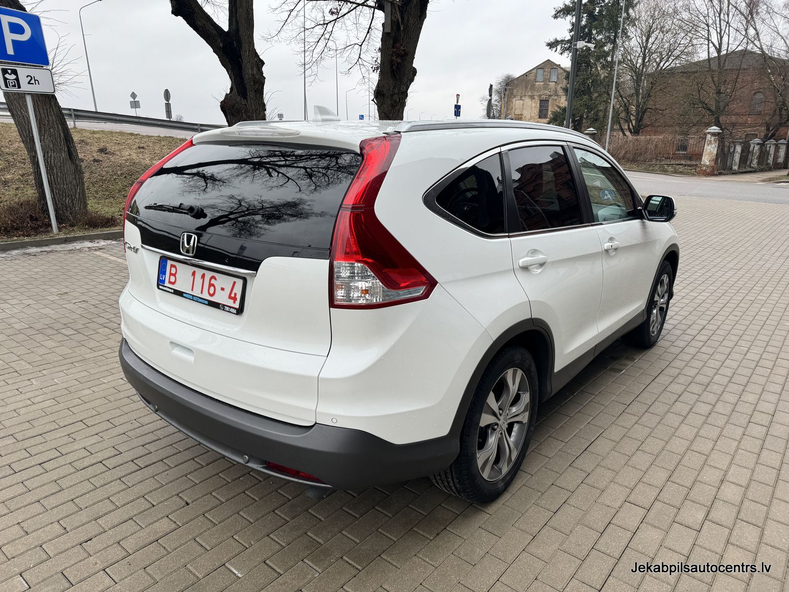 Autostāvvietā ir novietota balta honda cr v.