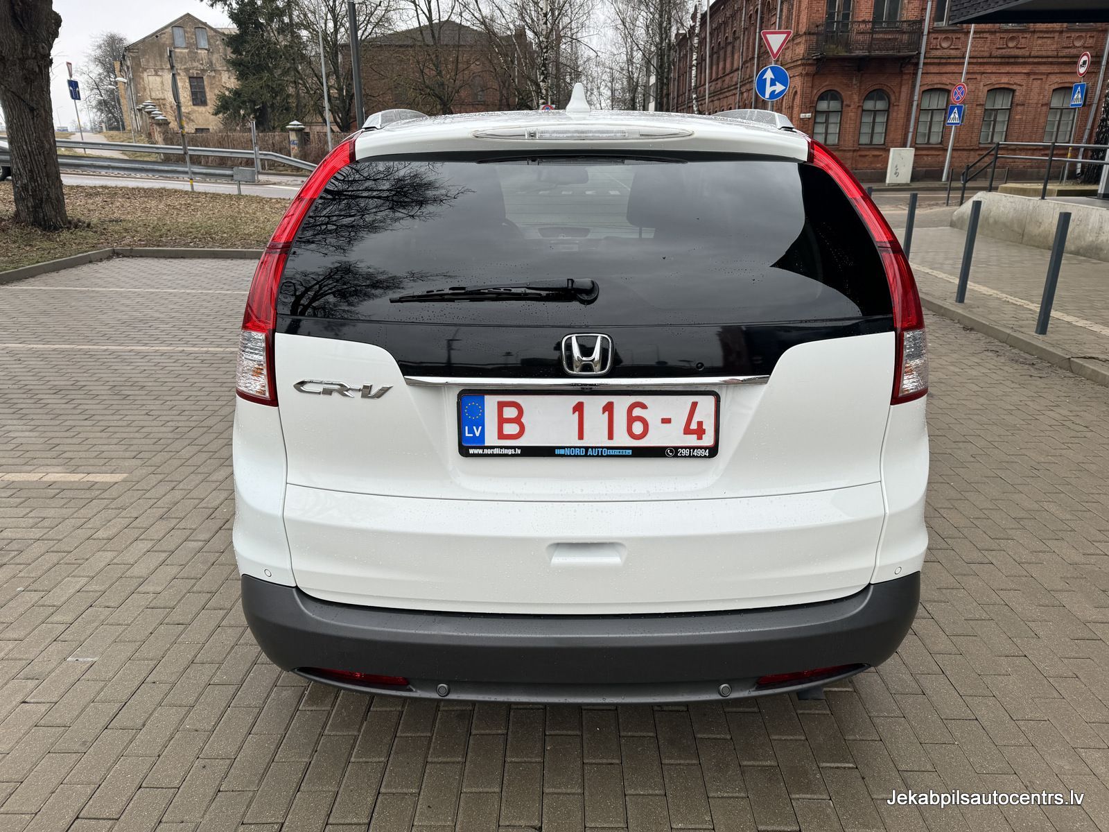 Autostāvvietā ir novietota balta honda cr v.