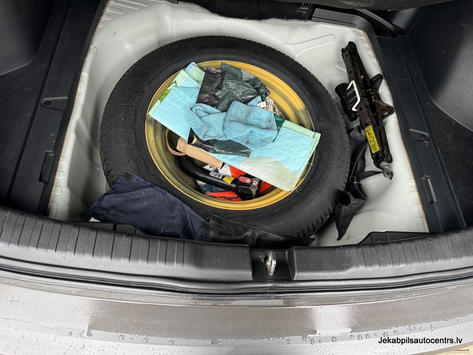 Rezerves riepa atrodas automašīnas bagāžniekā.