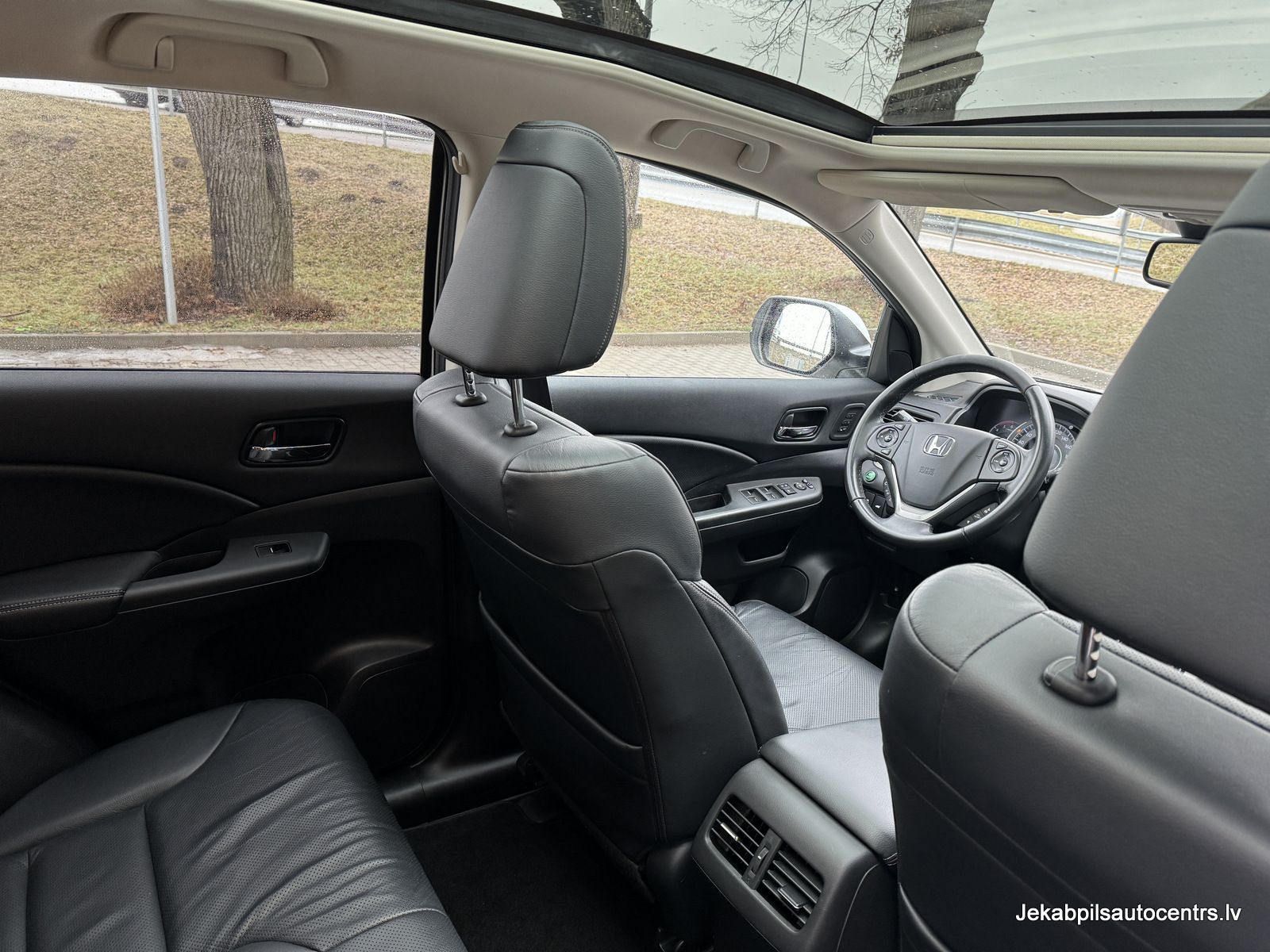 Automašīnas iekšpuse ar jumta lūku un ādas sēdekļiem.