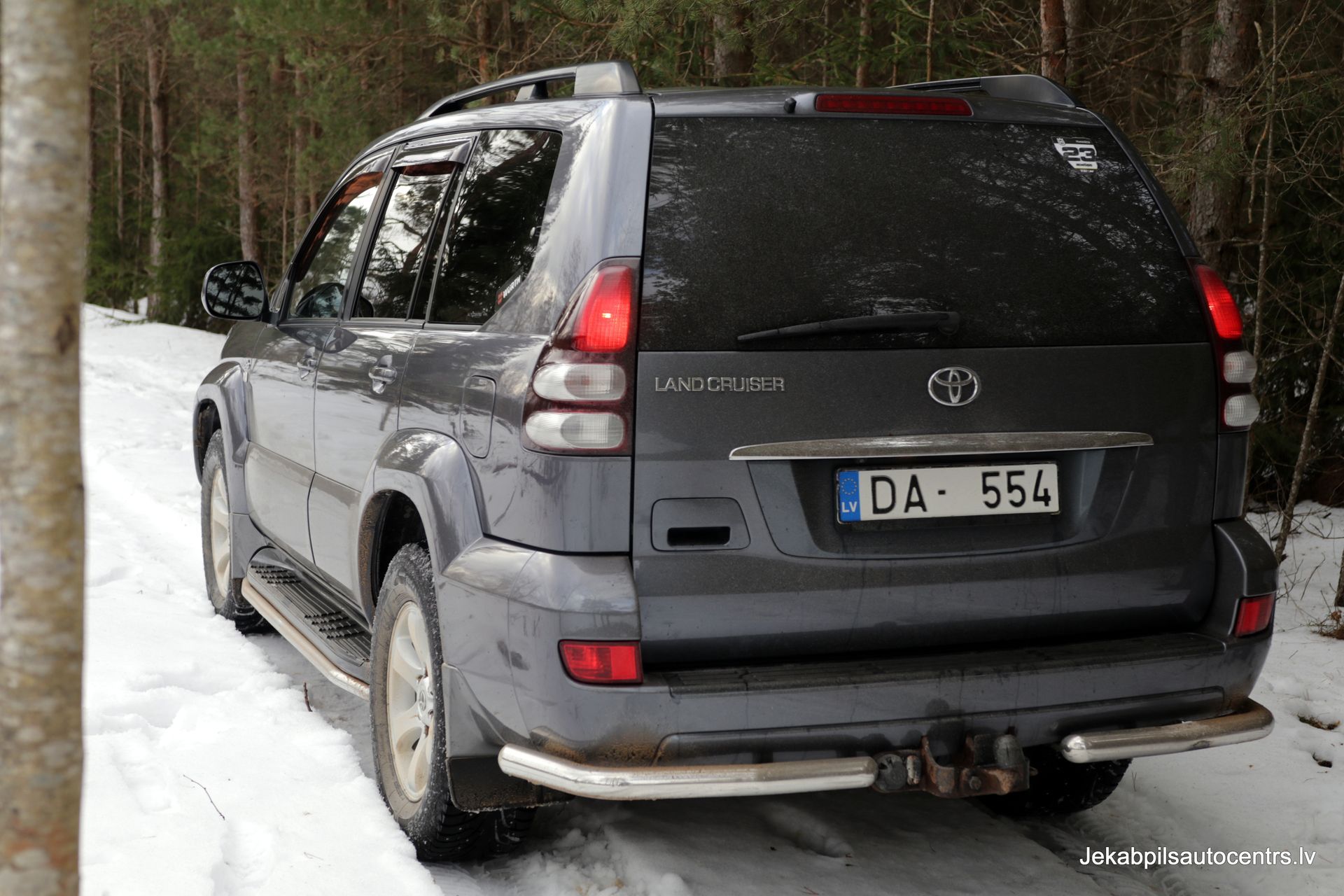 Automašīna ar numura zīmi da-554 ir novietota sniegā.