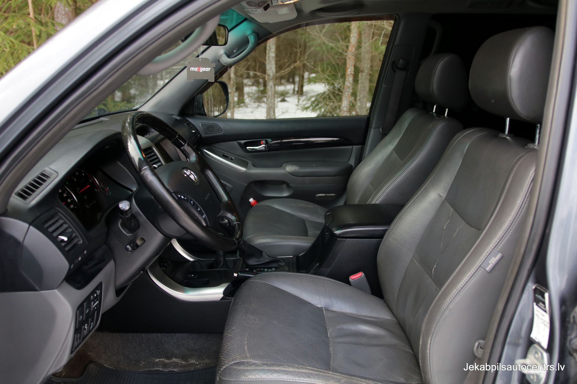 Automašīnas salons ar ādas sēdekļiem un stūri.