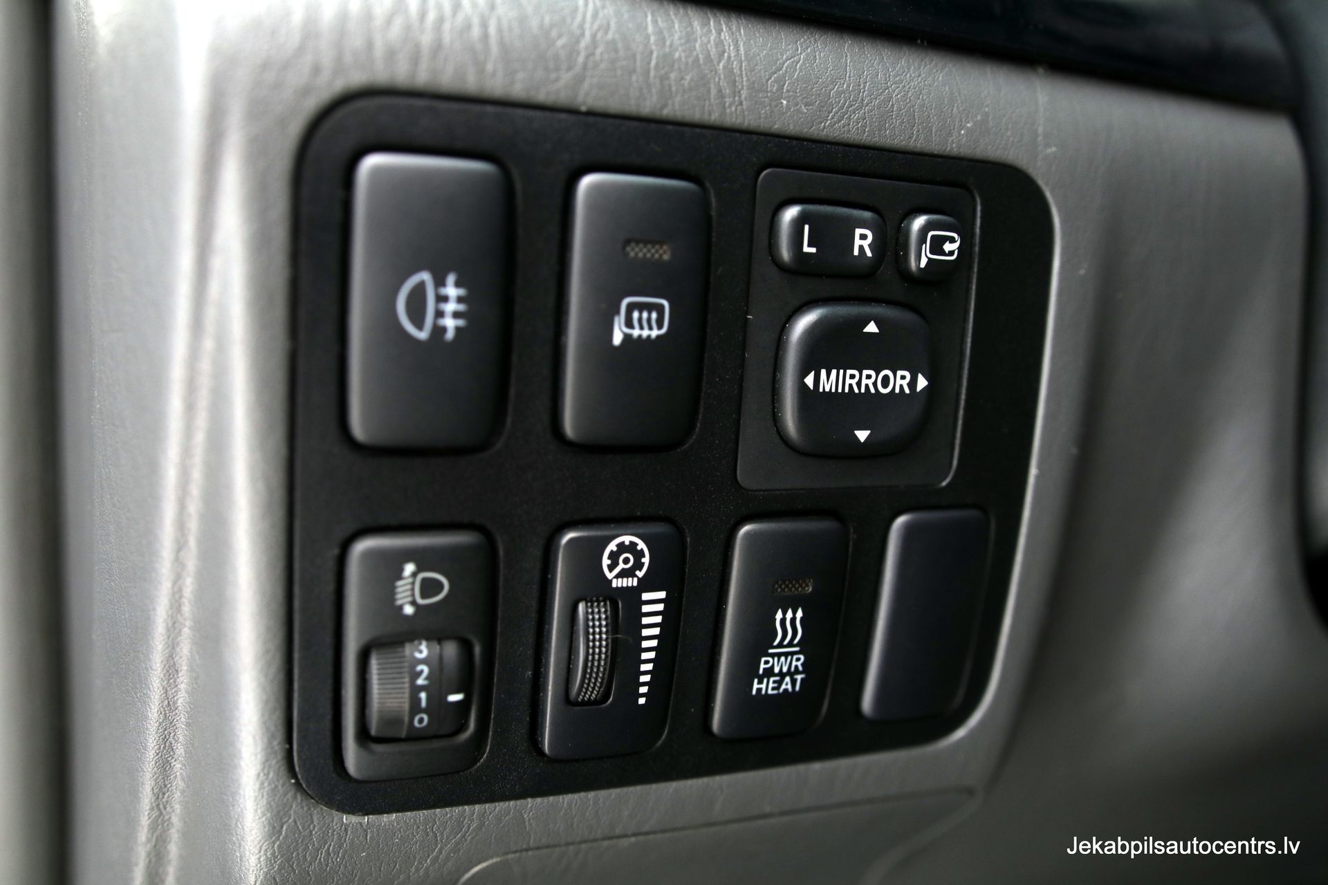 Tuvplāns no automašīnas paneļa ar dažām pogām