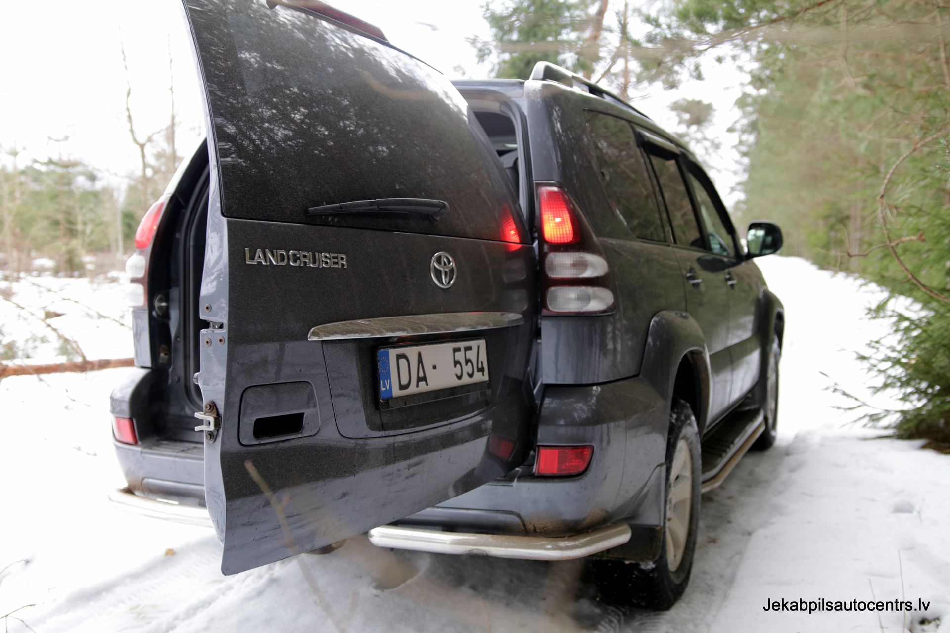 Sauszemes kreiseris stāv sniegā ar atvērtām durvīm