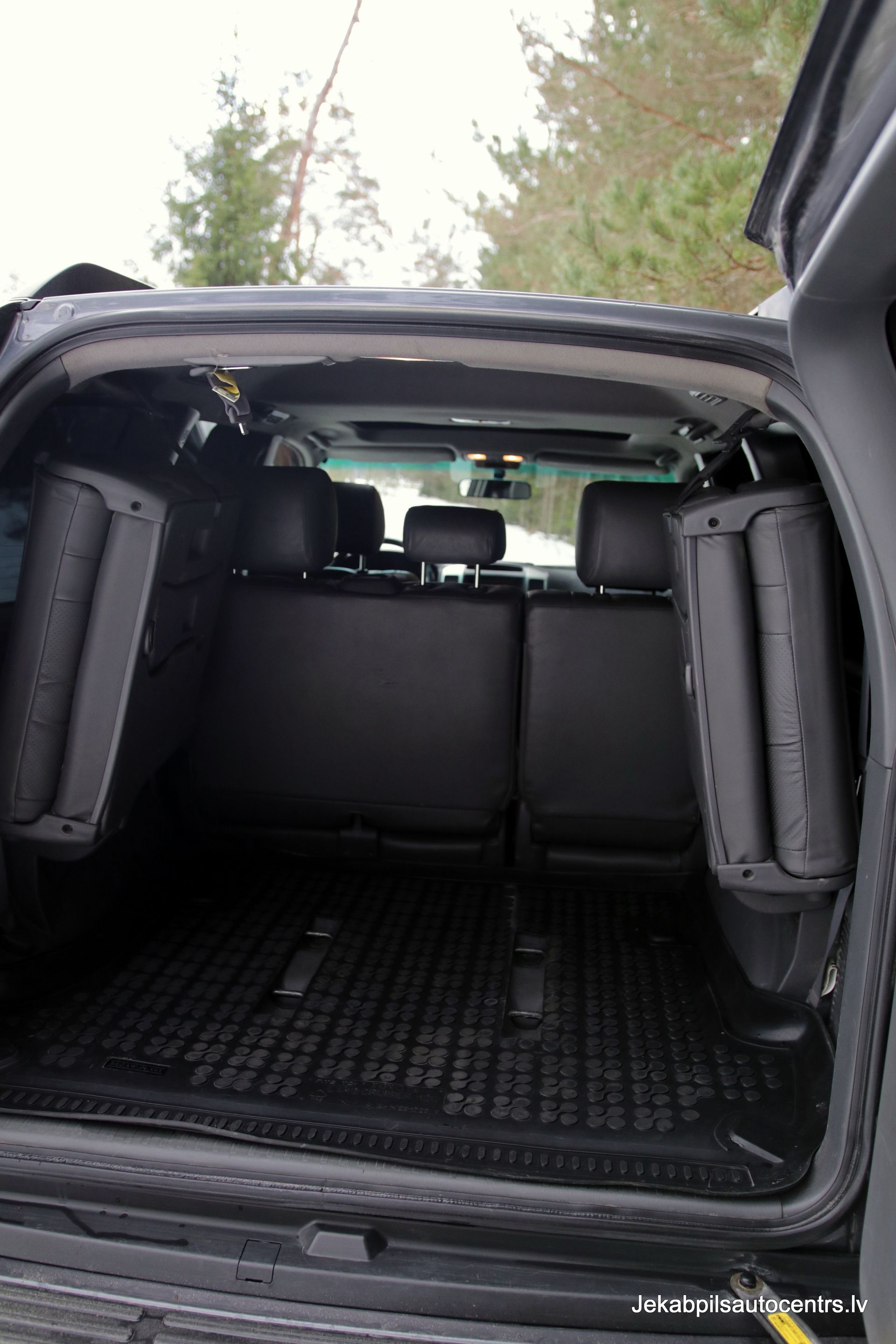 Melna apvidus auto aizmugure ar atvērtu bagāžnieku.