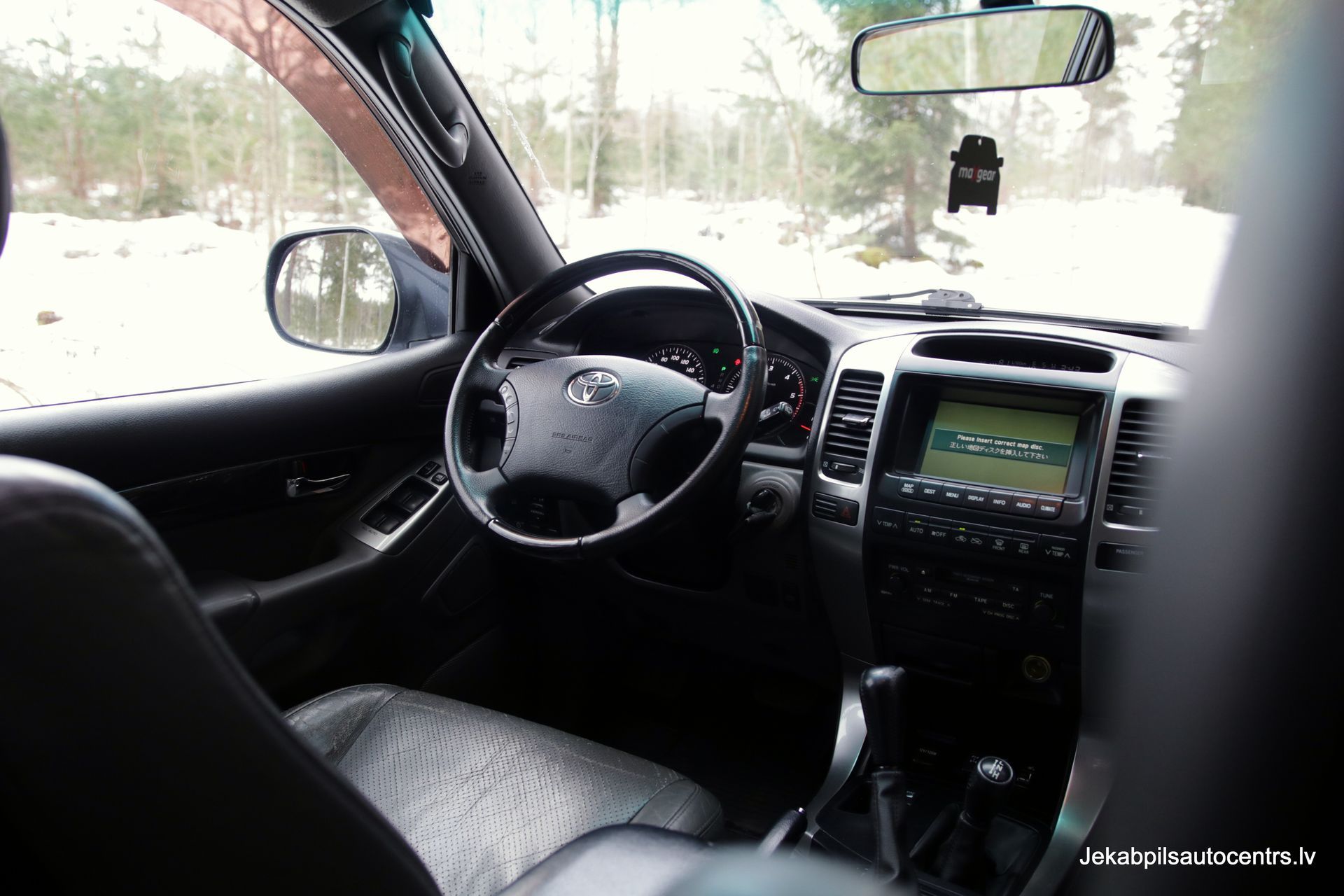 Automašīnas iekšpuse ar stūri un atpakaļskata spoguli