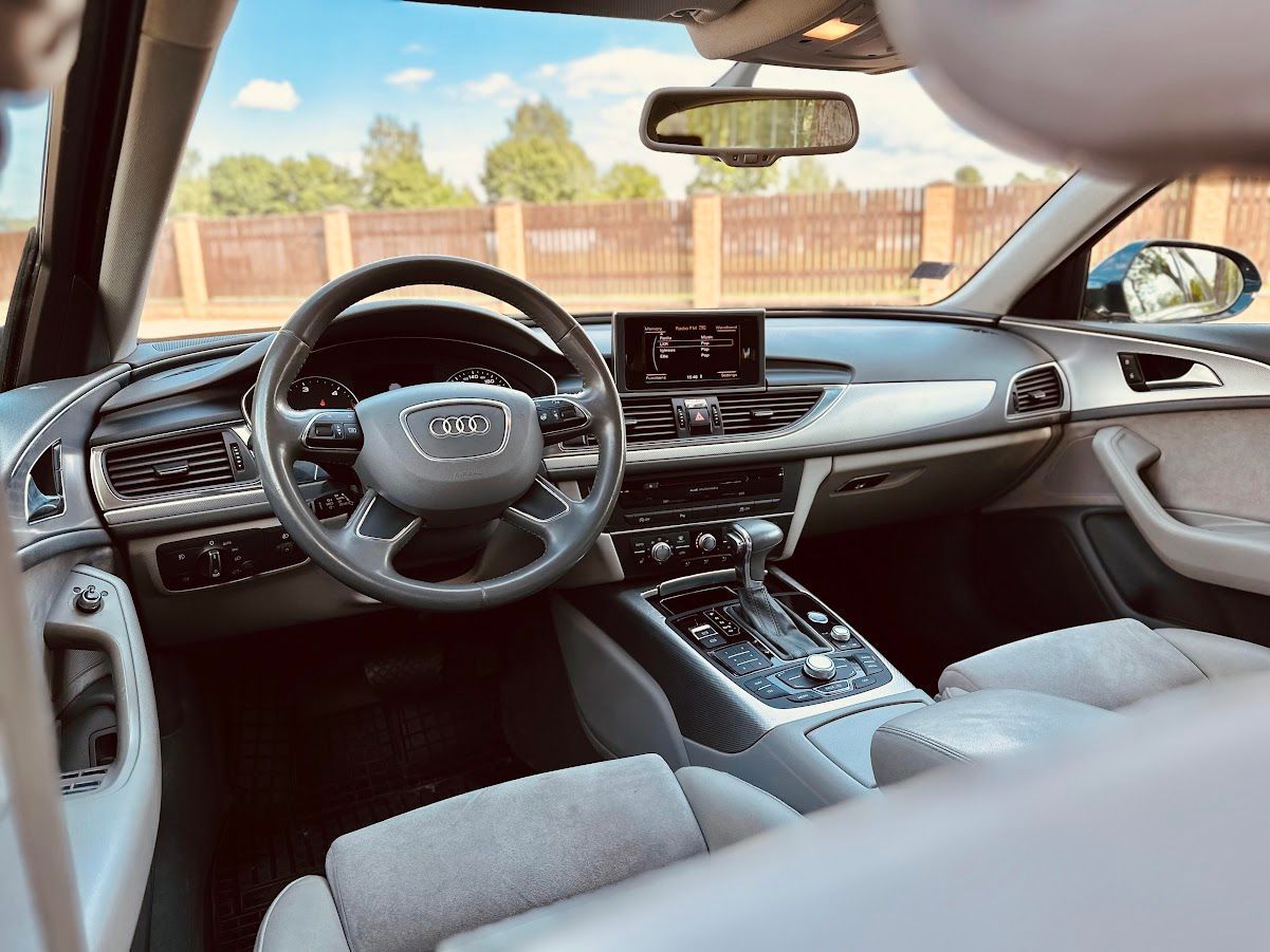 Automašīnas salons ar stūri un atpakaļskata spoguli.