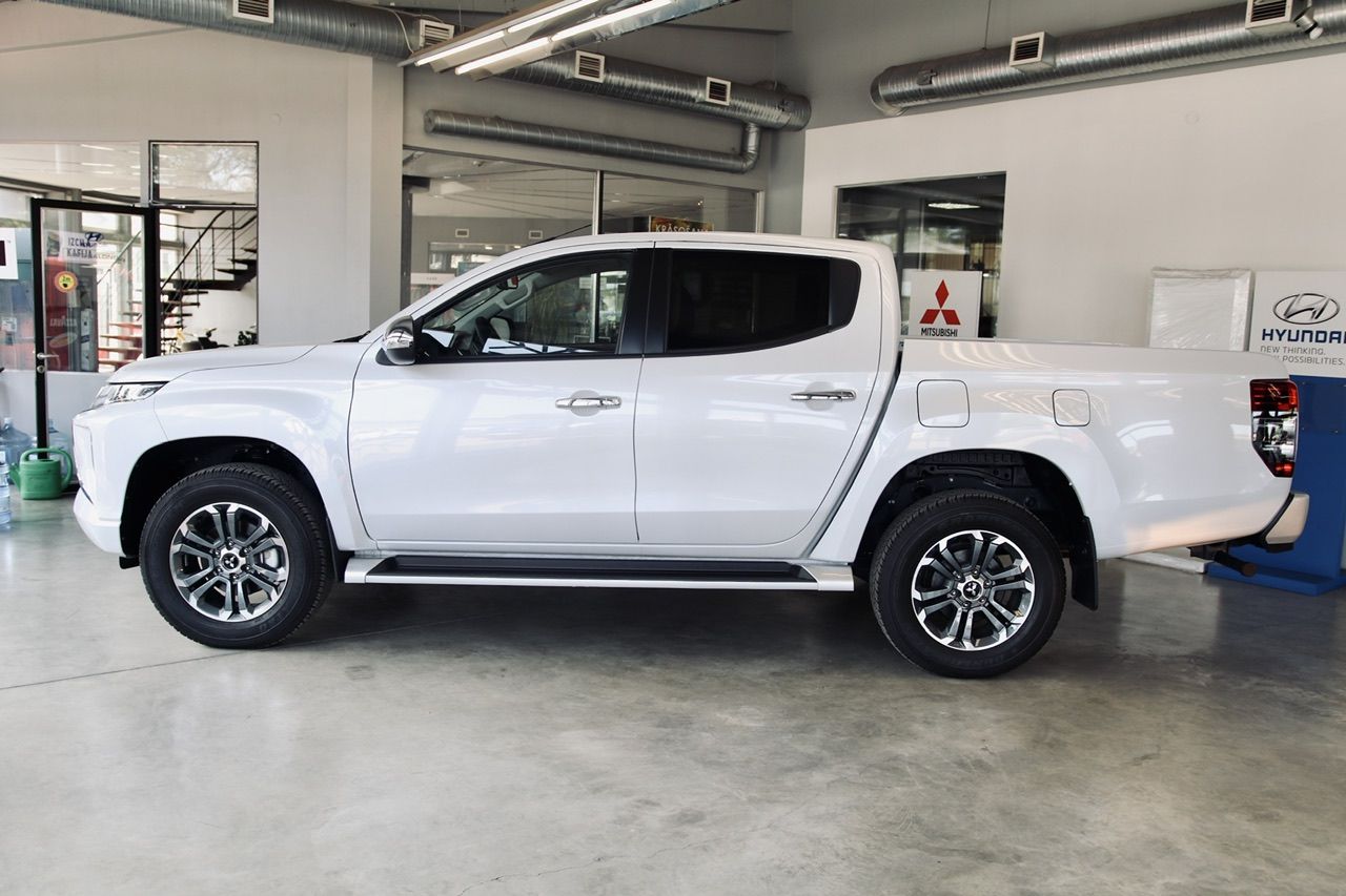 Izstāžu zālē stāv balts pikaps.