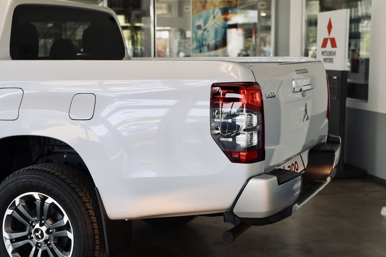 Izstāžu zālē stāv balts pikaps.