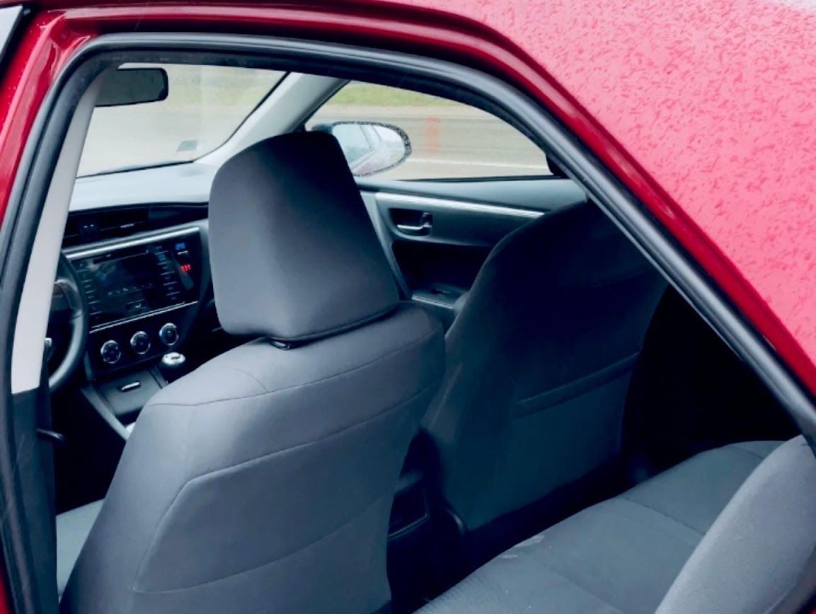 Sarkanas automašīnas iekšpuse ar pelēkiem sēdekļiem