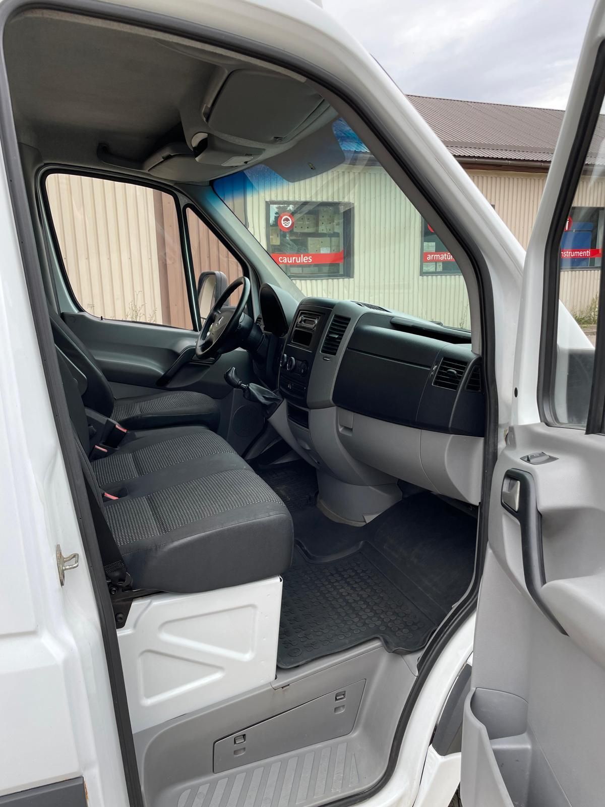 Balta furgona iekšpuse ar atvērtām durvīm