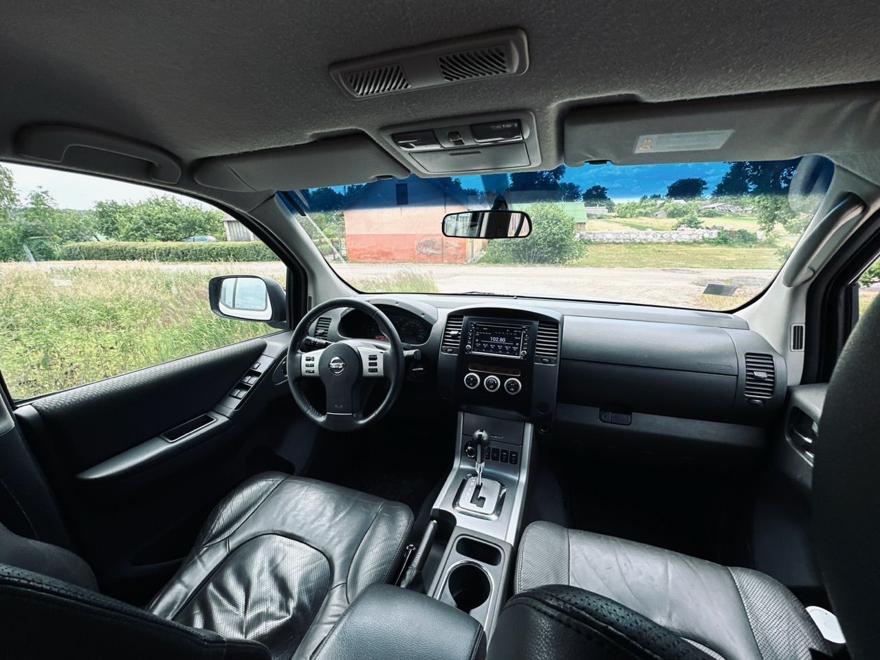 Automašīnas iekšpuse ar stūri un instrumentu paneli.