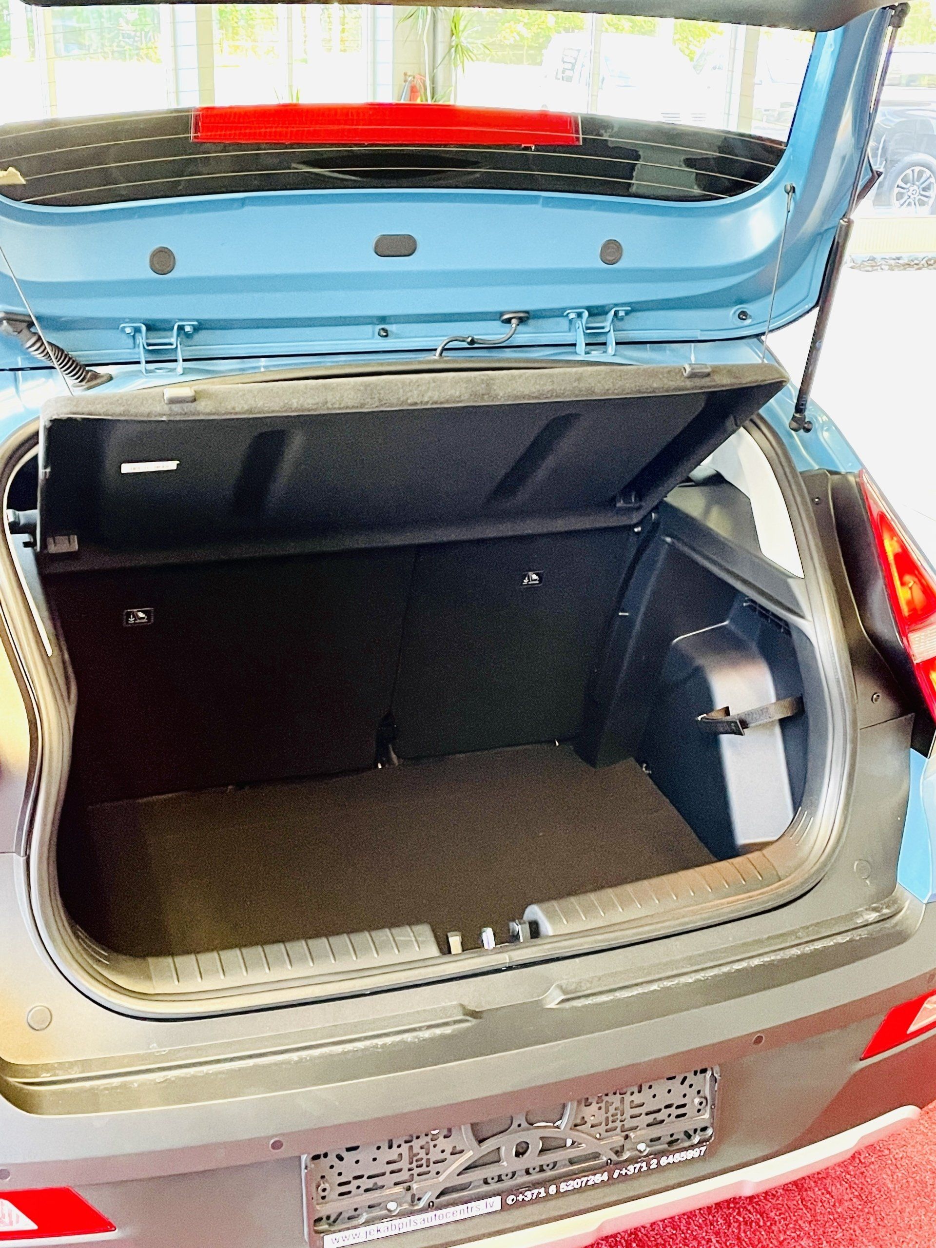 Zilas mašīnas bagāžnieks ir vaļā un tukšs.