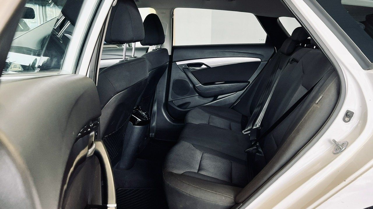 Baltas automašīnas aizmugurējais sēdeklis ar melniem sēdekļiem