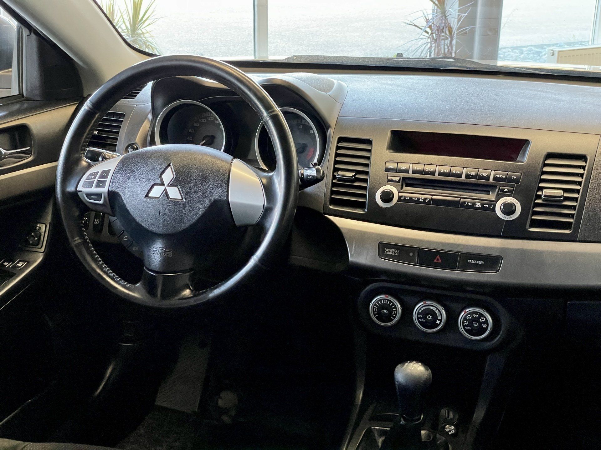 Automašīnas mitsubishi interjers ar stūri un radio