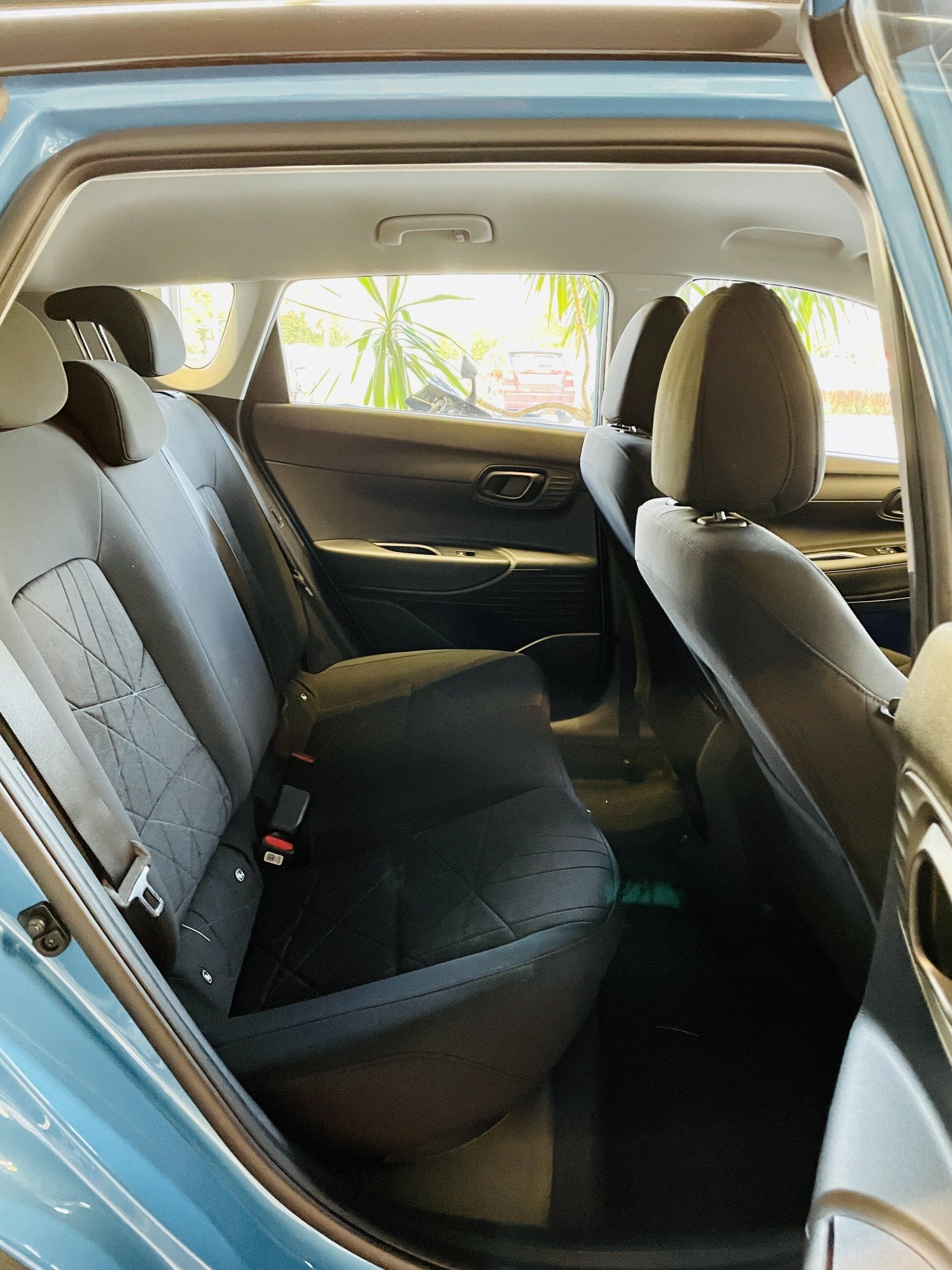 Zilas automašīnas aizmugurējais sēdeklis ar melniem sēdekļiem