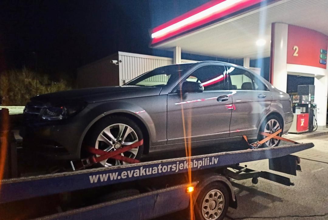 Degvielas uzpildes stacijā ar evakuatoru velk automašīnu.