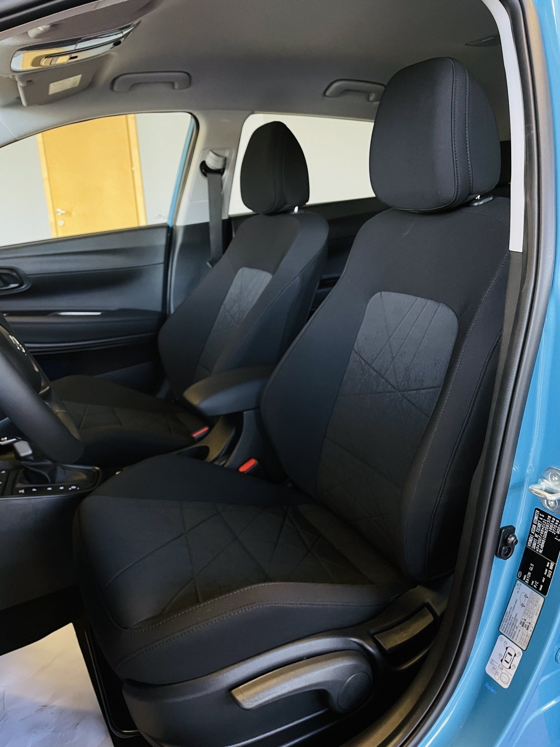 Zila mašīna ar melniem sēdekļiem un stūri