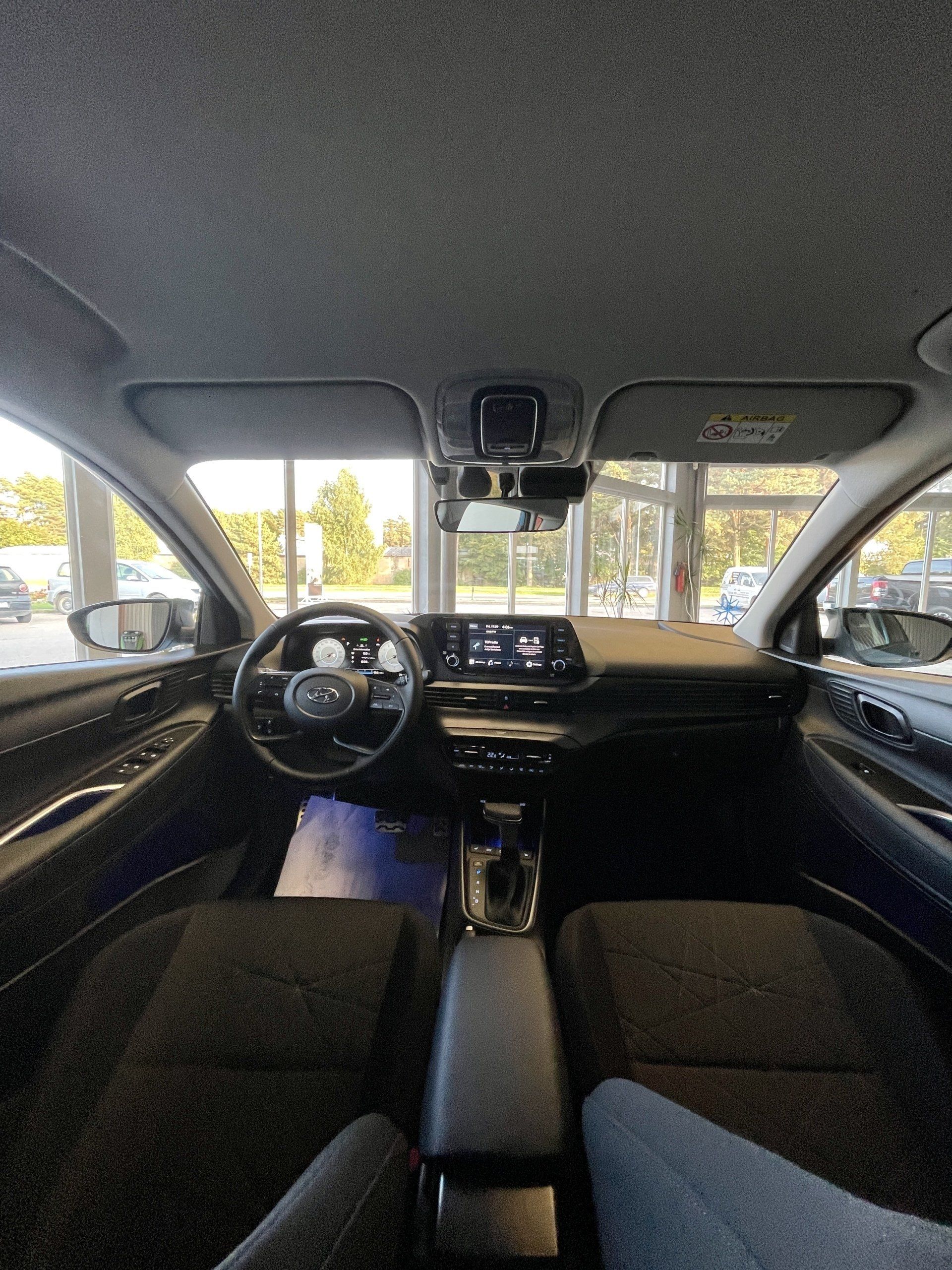 Persona sēž automašīnas vadītāja sēdeklī.