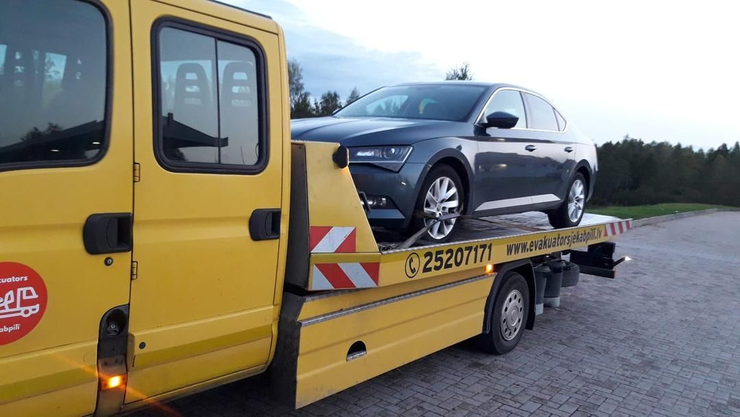 Automašīnu velk dzeltens evakuators.
