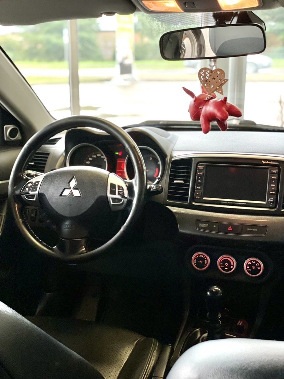 Automašīnas iekšpuse ar stūri un atpakaļskata spoguli.