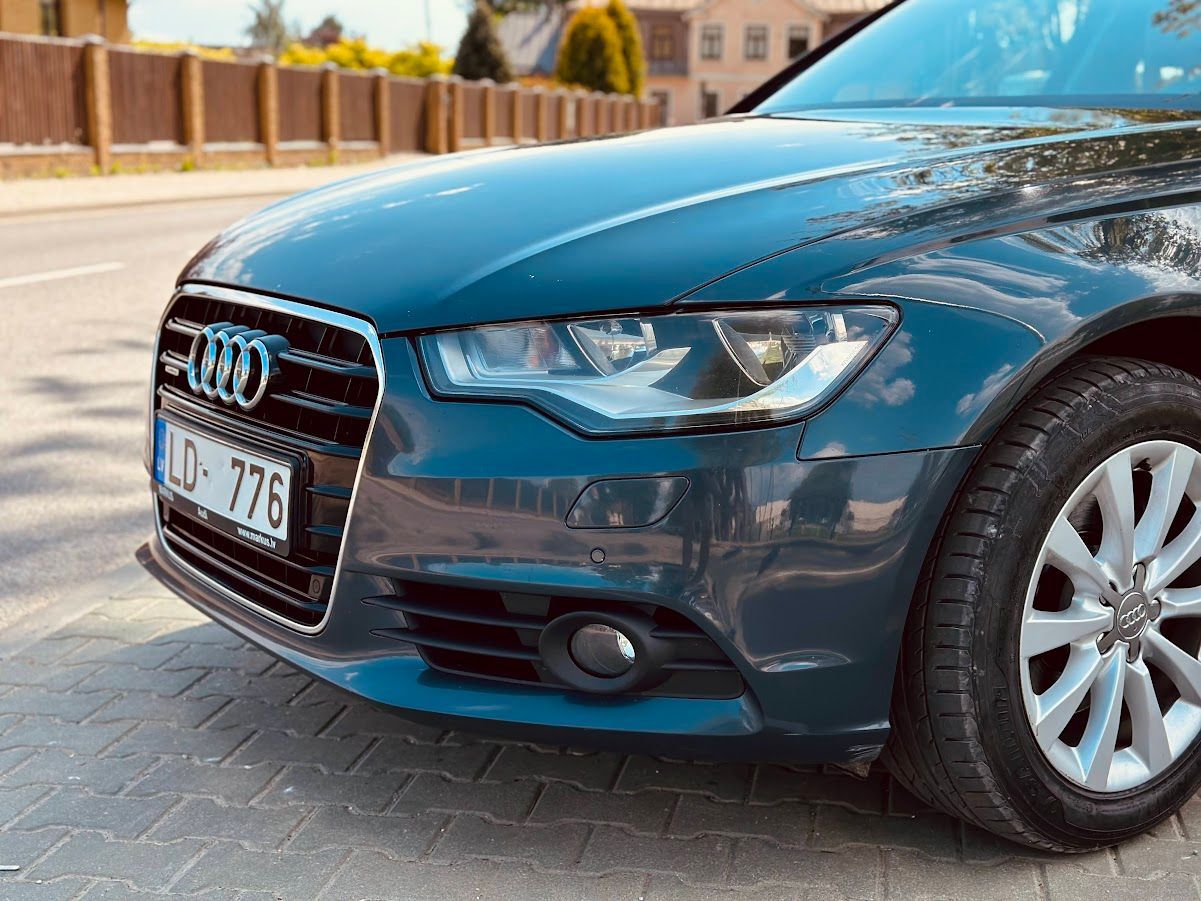 Ceļa malā stāv zils audi a6.